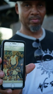 A man shows a photo important to him about his community.