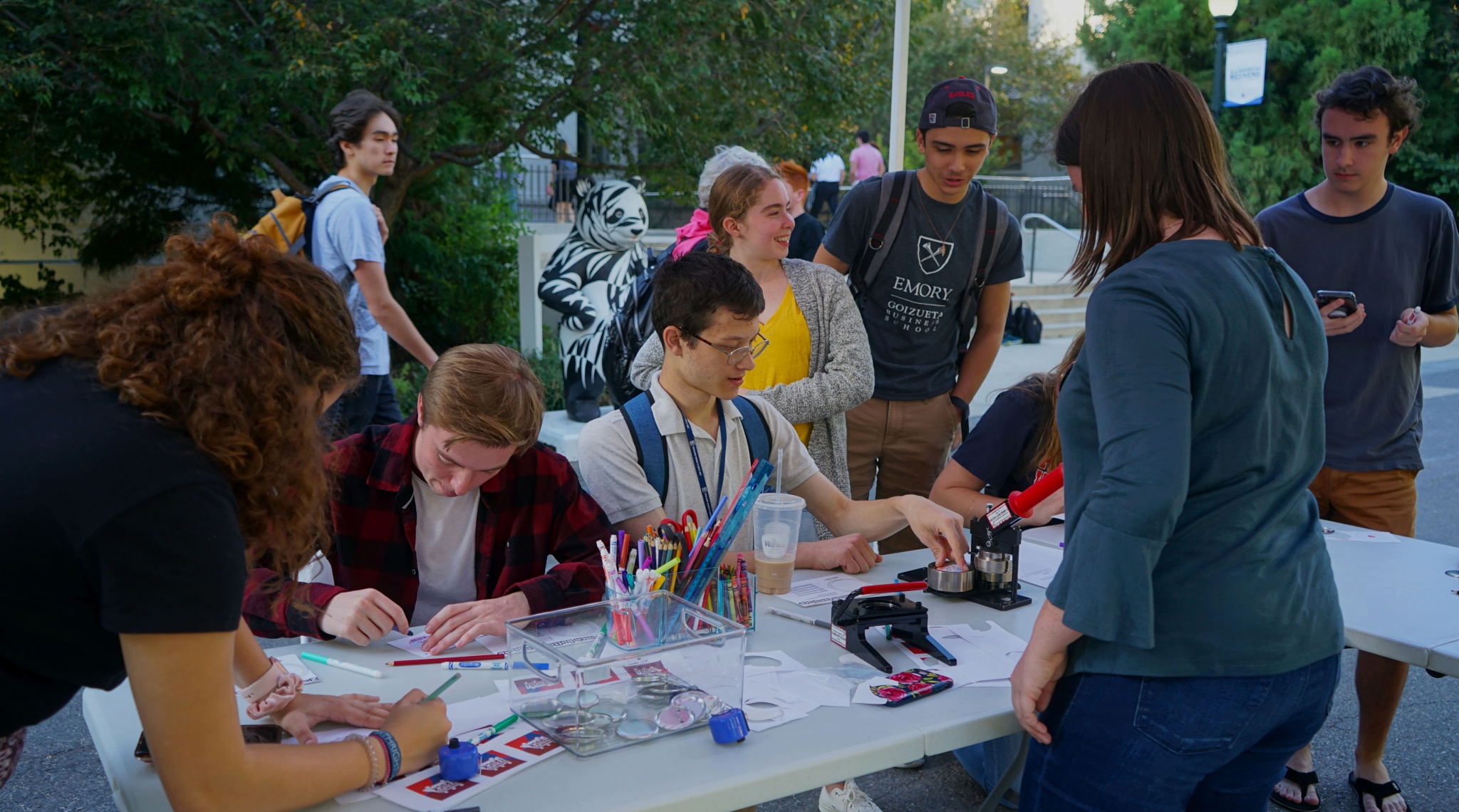 Jenna Goff assists a crowd of people in creating buttons about what activism means to them.